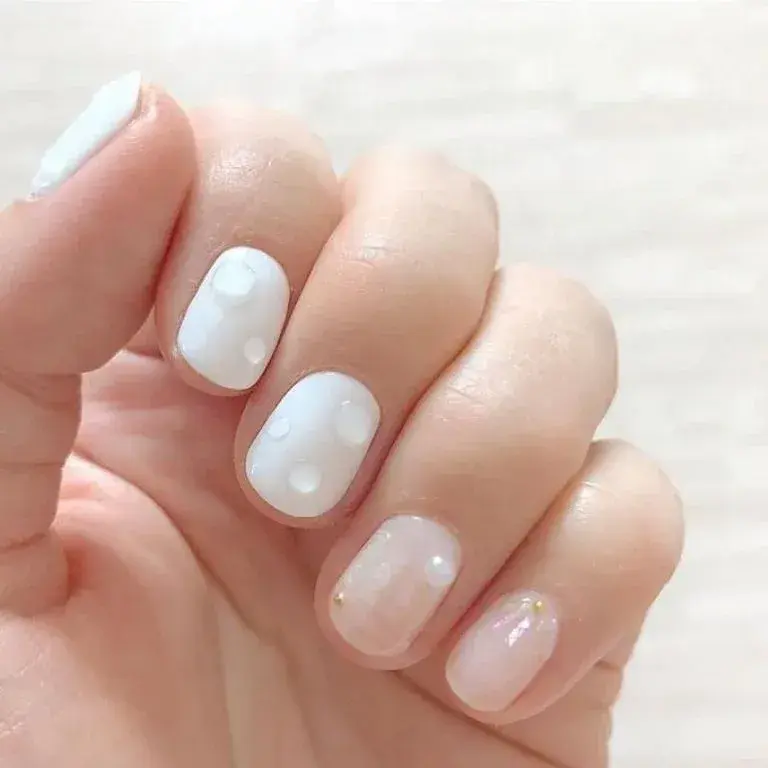 Uñas efecto wet o mojado en colores claros como nude o blancos.