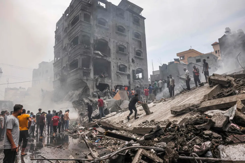 Palestinos buscan supervivientes después de un ataque aéreo israelí contra edificios en el campo de refugiados de Jabalia, en la Franja de Gaza, el 9 de octubre de 2023.