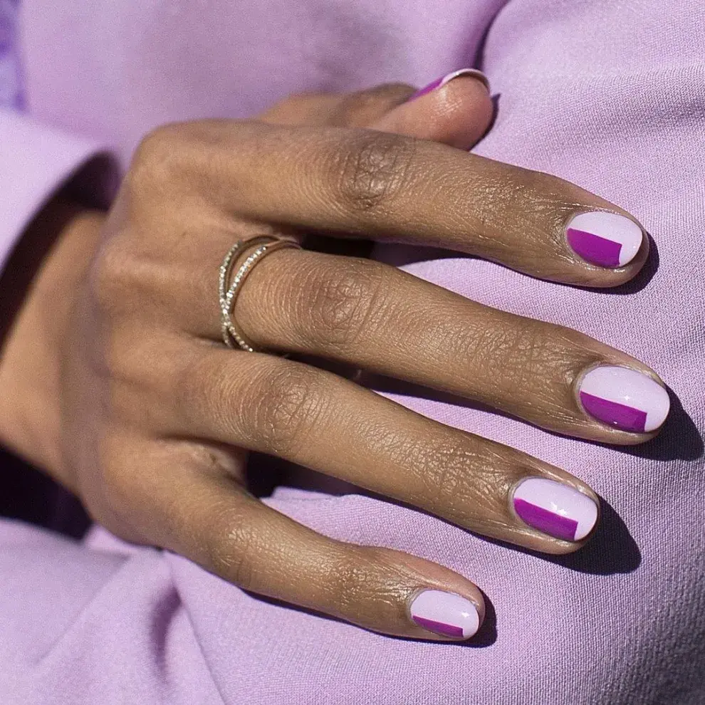 Uñas con estilo geométrico, combinando el púrpura con el blanco.
