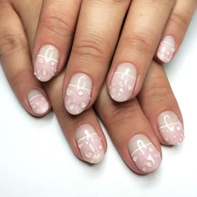 Uñas efecto wet o mojado en colores claros, sumando diseño.