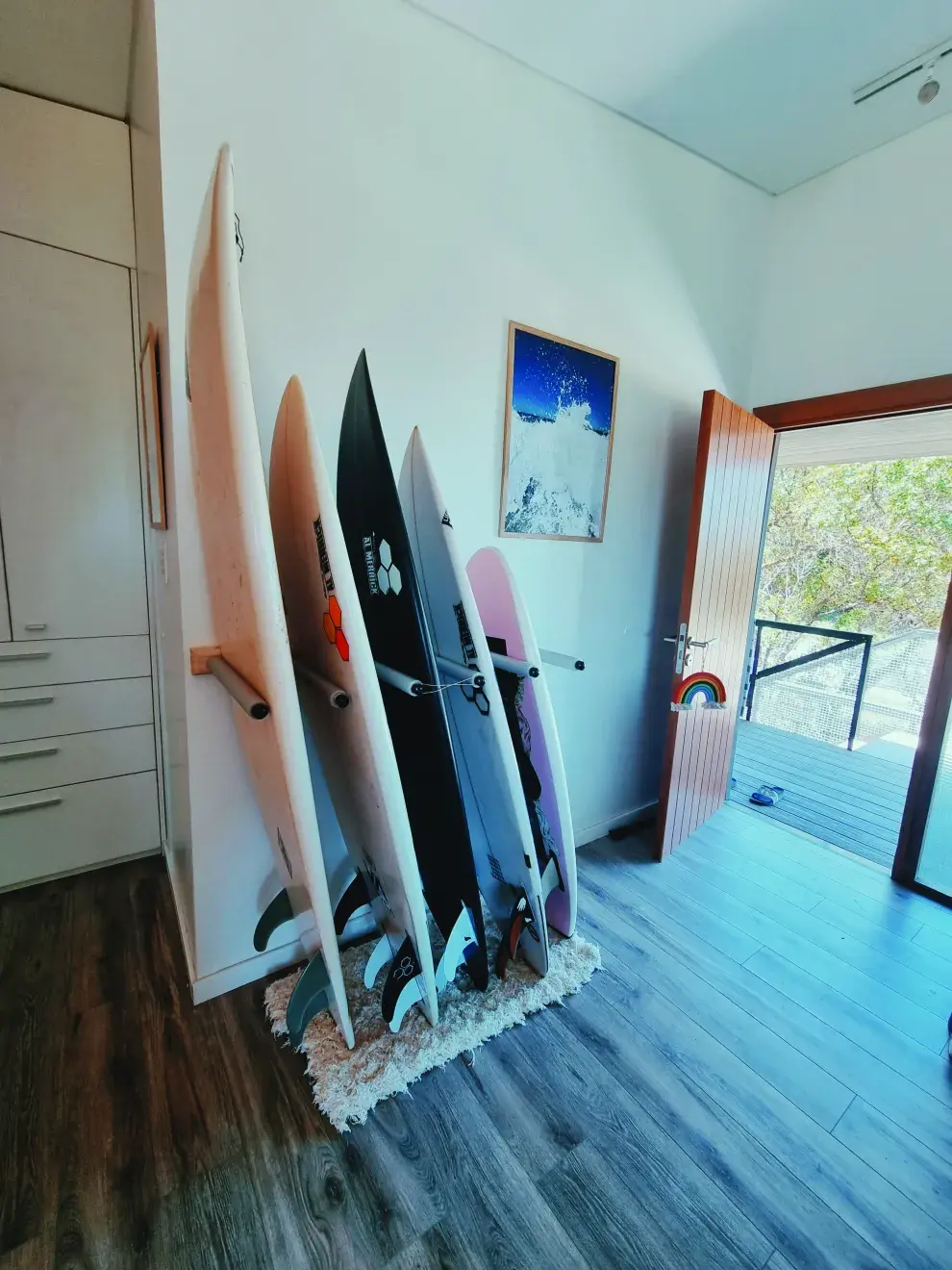 En la entrada, te recibe un portatablas artesanal que habla del estilo surfer de la casa.