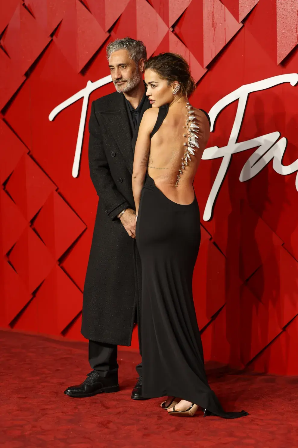 Taika Waititi y Rita Ora en la alfombra roja de los Fashion Awards 2023.