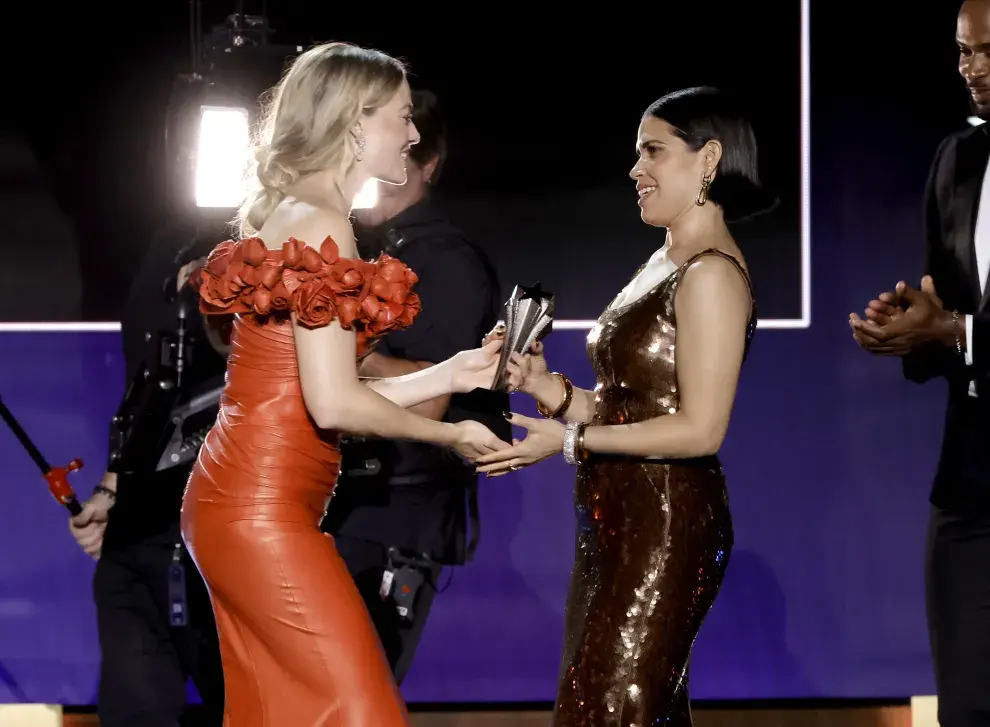 Margo Robbie le entrega a America Ferrera el premio SeeHer en los Critics Choice Awards 2024.