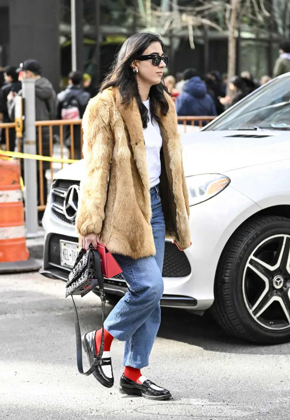 Un look casual súper chic. Remera básica, jean recto, abrigo de piel y mocasines. ¿El detalle? Las medias rojas que suman un toque canchero.