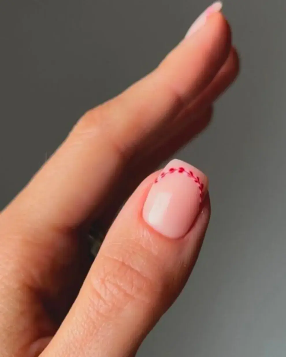 Sobre un brillito con tono blanco o rosado, unos puntitos unidos por una línea.