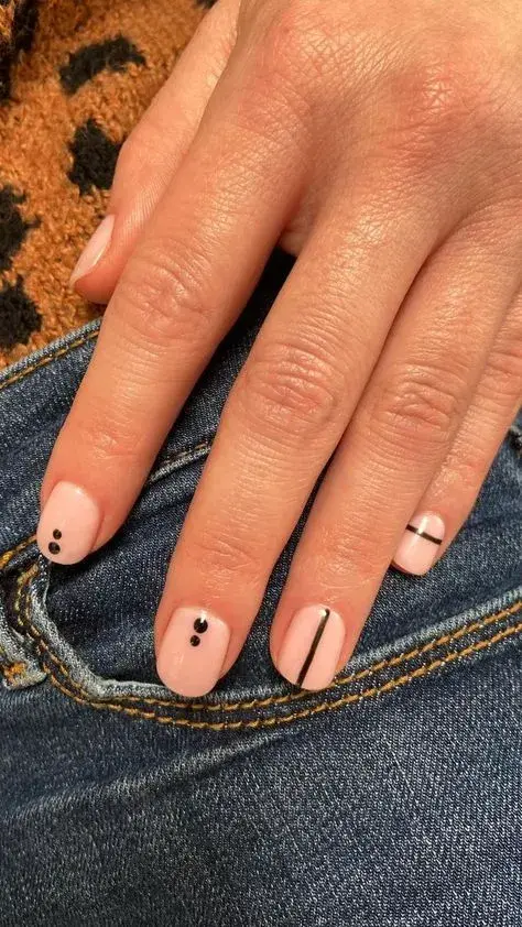 Una opción si te gusta el "nail art" más geométrico, pero esta vez combinando puntos con algunas líneas, todo en esmalte negro.