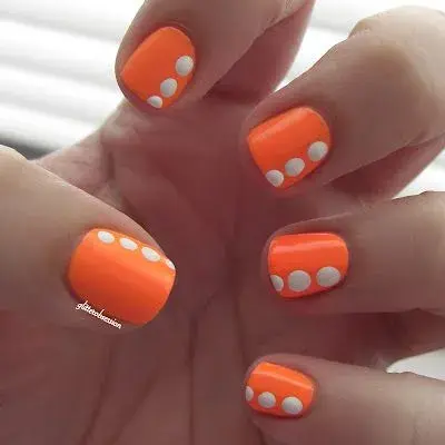 "Nail art" bien veraniego, en tono naranja y con "dots" grandes en color blanco para generar más contraste.