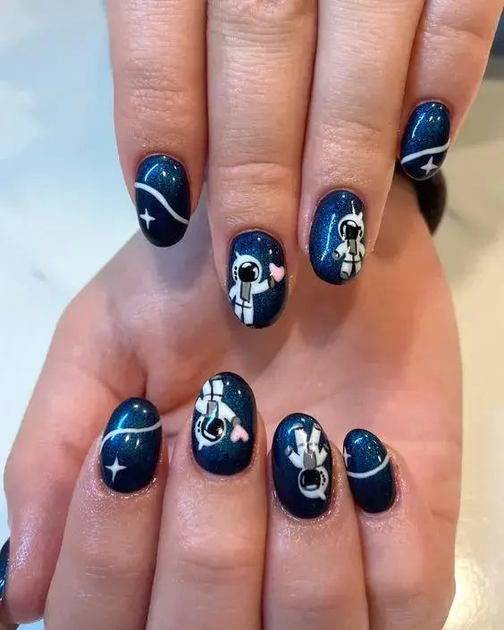 Un nail art holográfico y con astronautas. Divertido (y también muy cute, ¿no?).