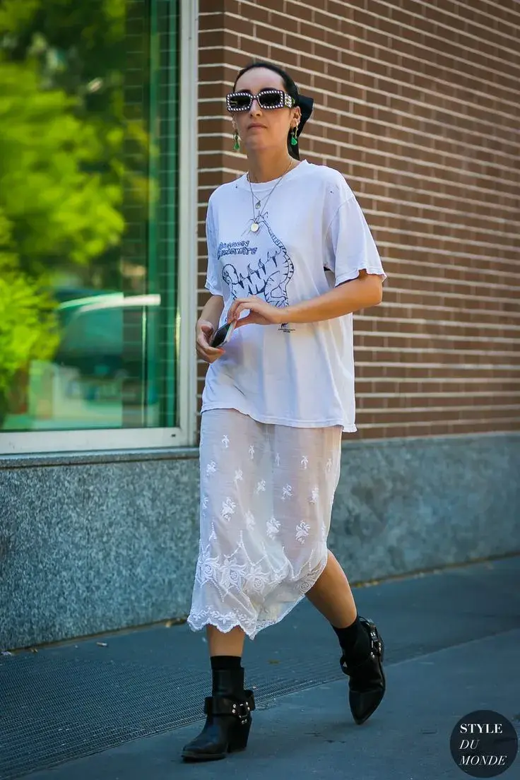 Remera blanca oversize con falda y botinetas.