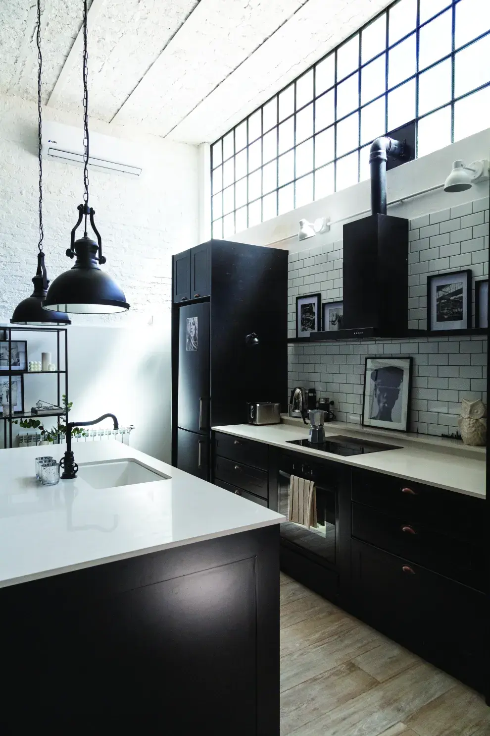 Cocina open concept con detalles de estilo neoyorquino: blanco y negro, vidrio repartido, azulejos subway y arte.