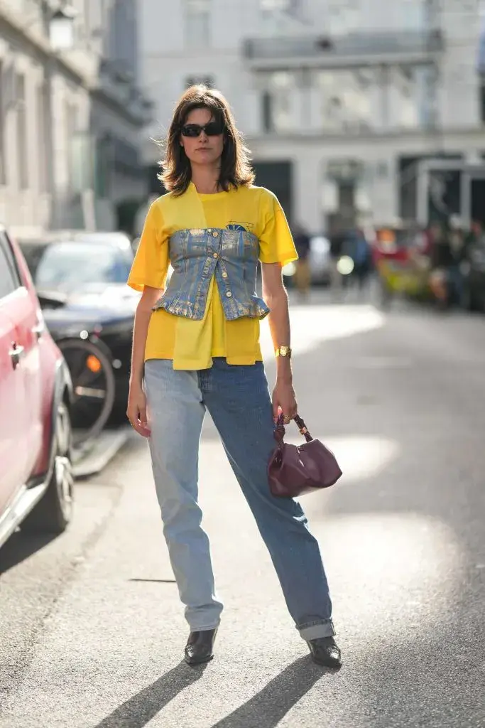 Corset de denim abierto y superpuesto combinado con pantalón duotono.