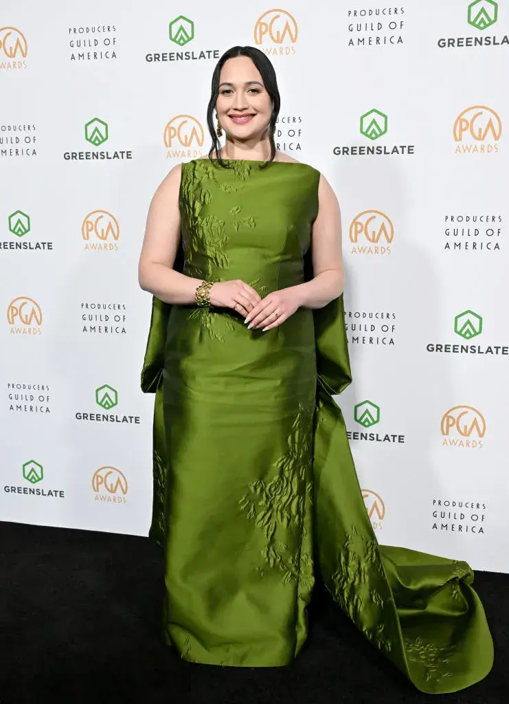 Lily Gladstone con un vestido verde oliva satinado.