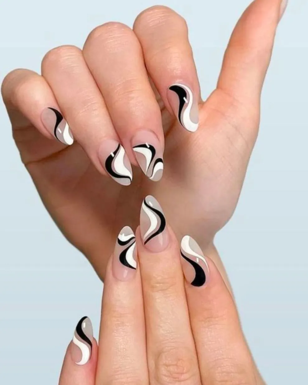 Sobre una base transparente, jugas con el curve nail art en blanco y negro.