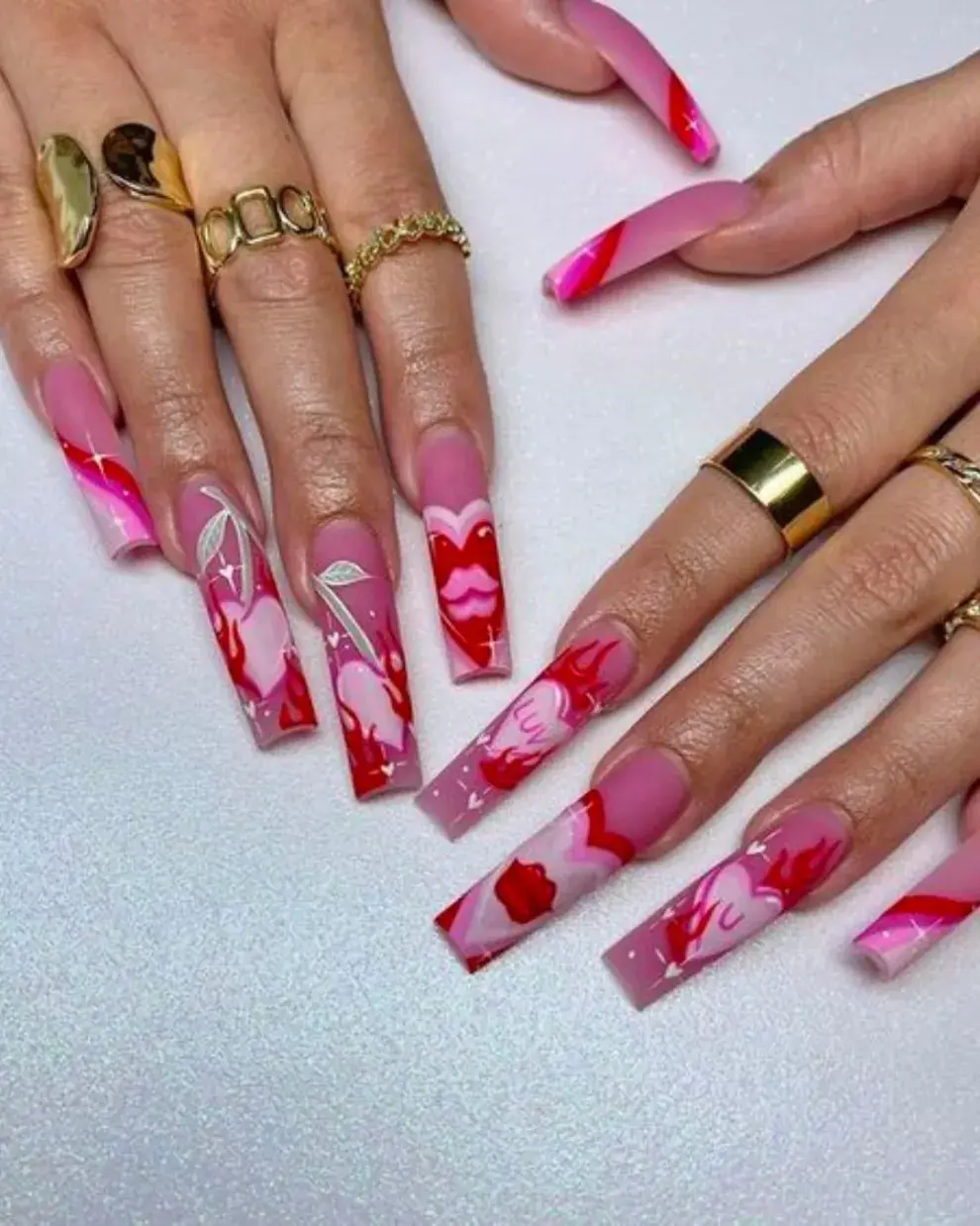 En plan coffin nails, un diseño repleto de amor y corazones en tonos rosas.