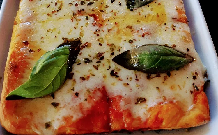 La clásica Margherita: queso, salsa de tomate y hojas de albahaca.