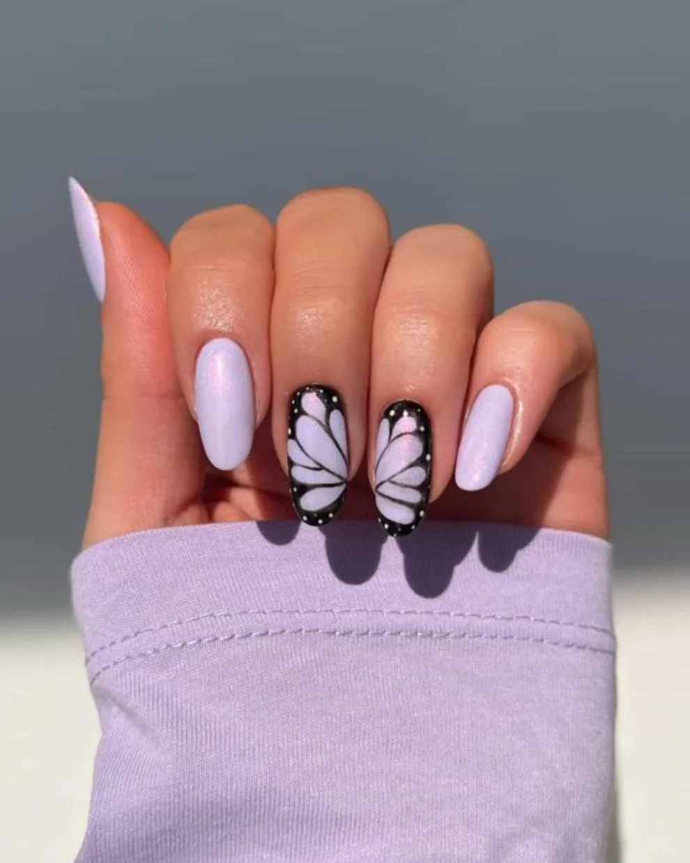 Creando un diseño continuo entre dos uñas, las mariposas están mega de moda.