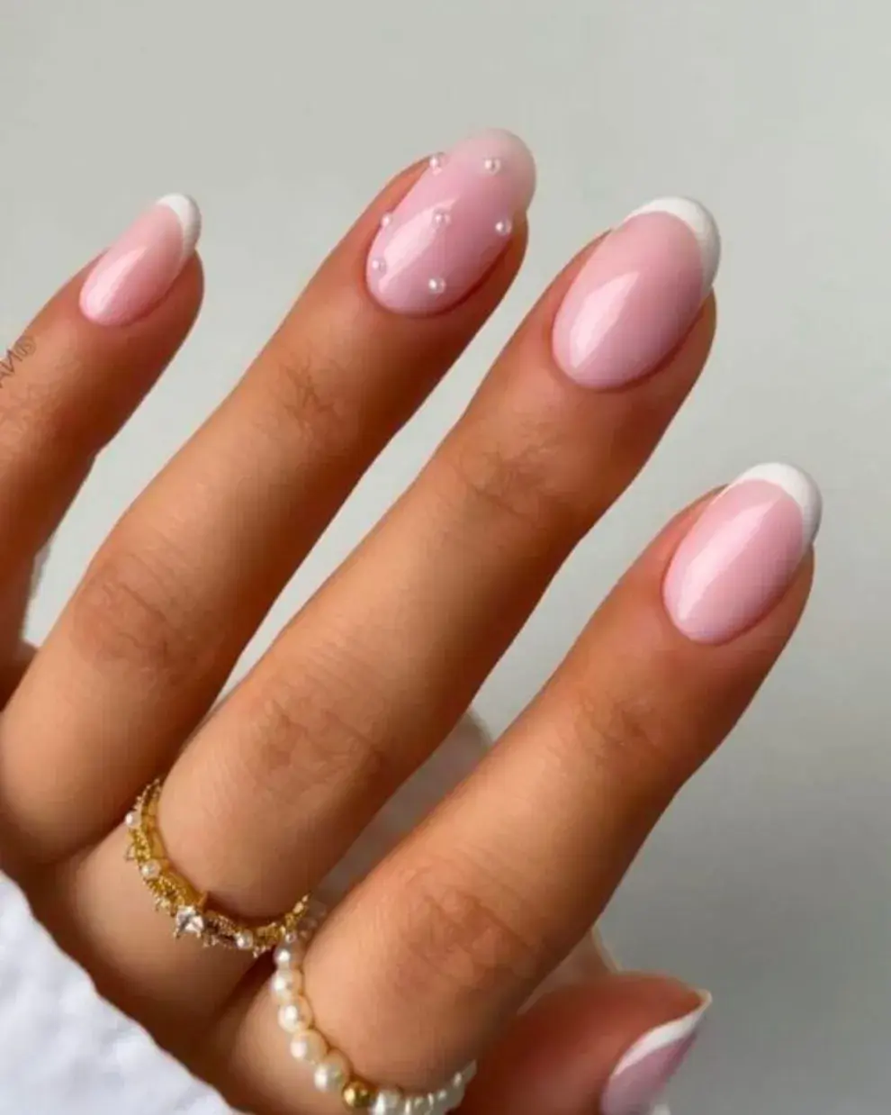 Usando la tendencia milky como base para una francesita, en una de las uñas sumás unas perlitas.