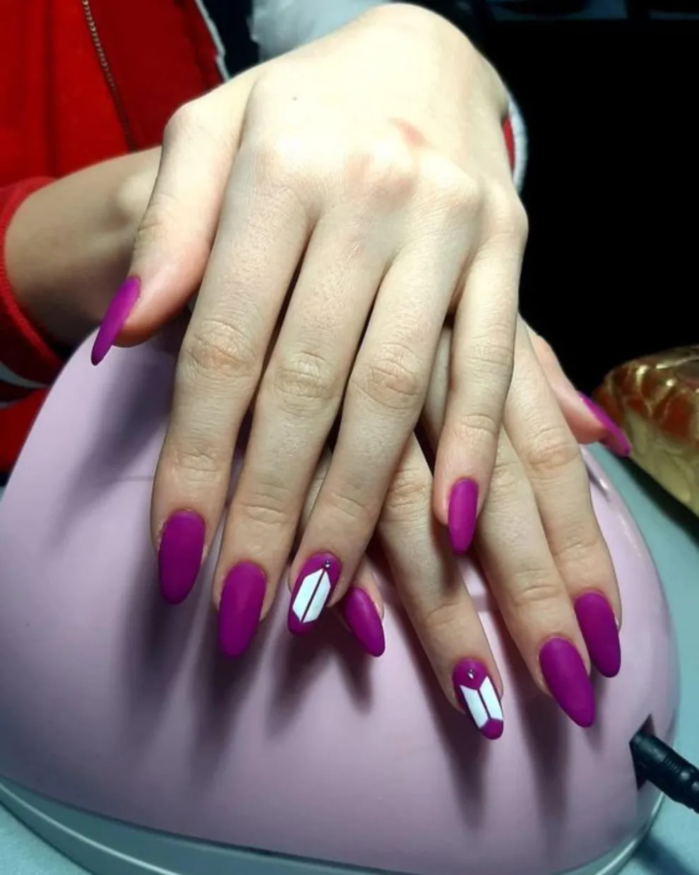 Usando el violeta como base -tono distintivo de ARMY- dibujás el logo de BTS en una de las uñas.