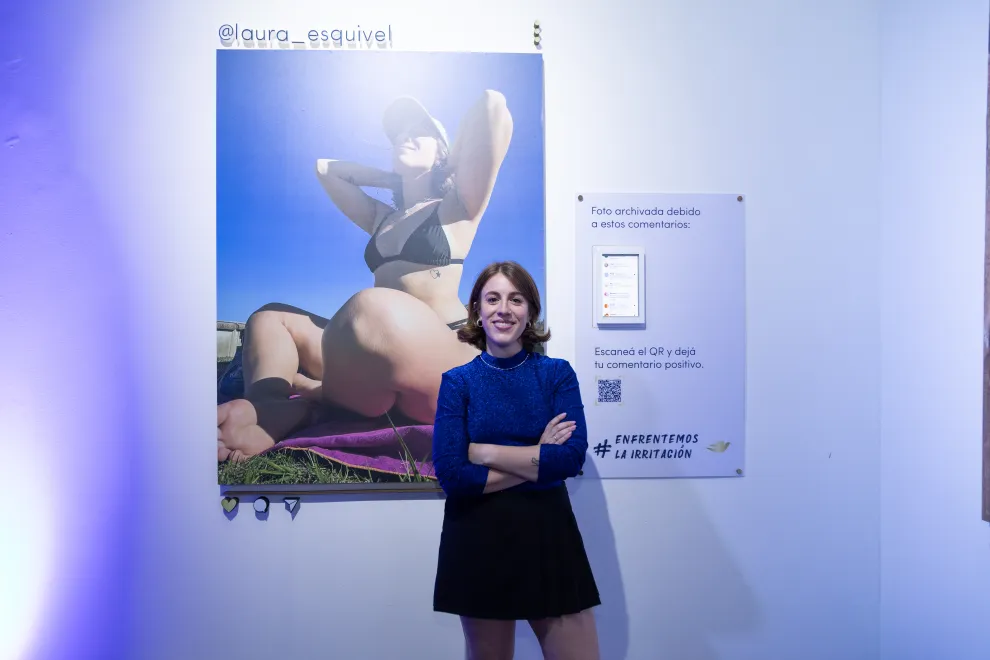 Laura Esquivel junto a su foto en la muestra: inspiración y seguridad en una sonrisa frente al odio.