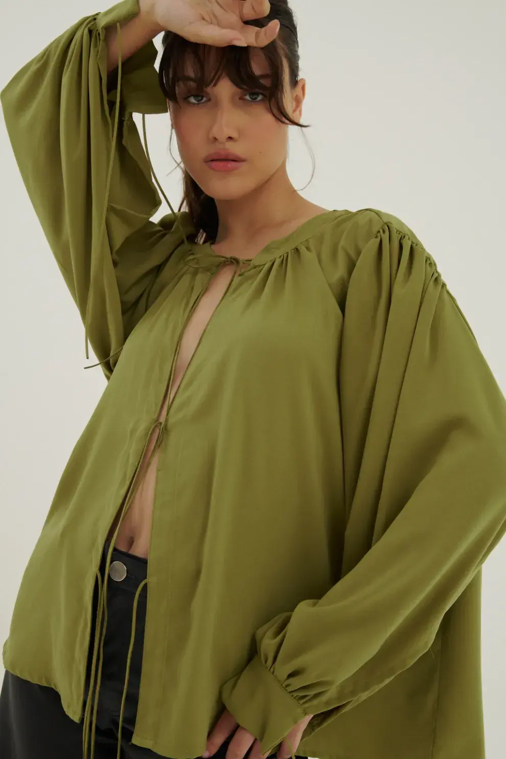 Blusa verde oliva confeccionada en tweel sastrero. Tiene frunces y tiras de cuero gamuzado a tono para atar. @farodeprana