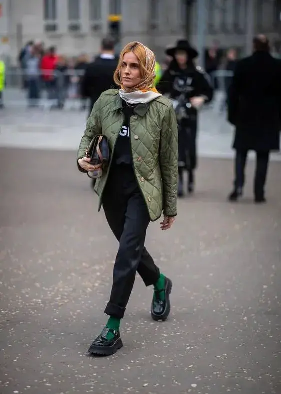 Las prendas no tienen que ser necesariamente de un mismo color, pero sí estar en la gama. Por ejemplo, en este look la campera y las medias están en la gama de verdes, mientras que el contraste se genera con prendas y calzado negros.