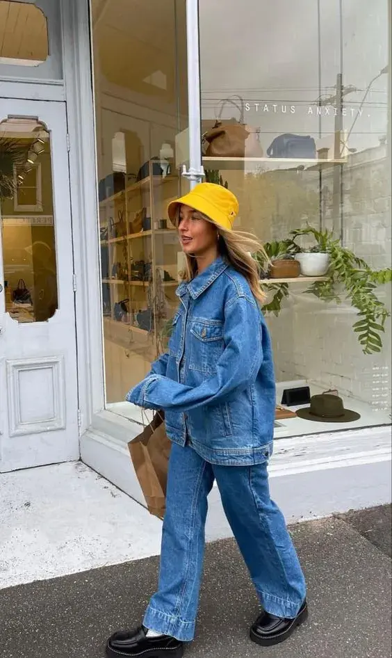 Un look total denim con un gorro amarillo para darle un contrapunto de color.