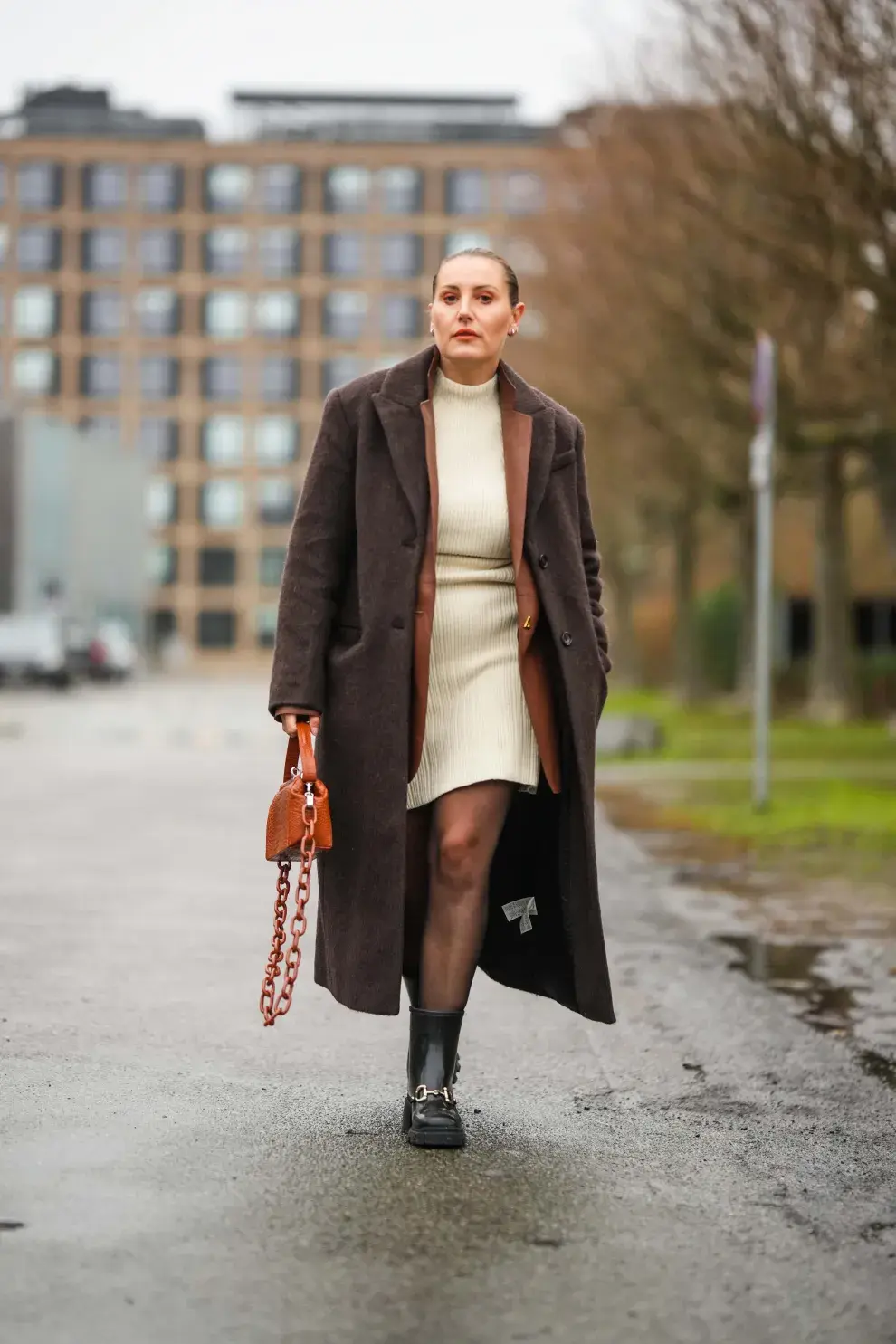 Vestido con medias traslúcidas, blazer oversize y tapado.