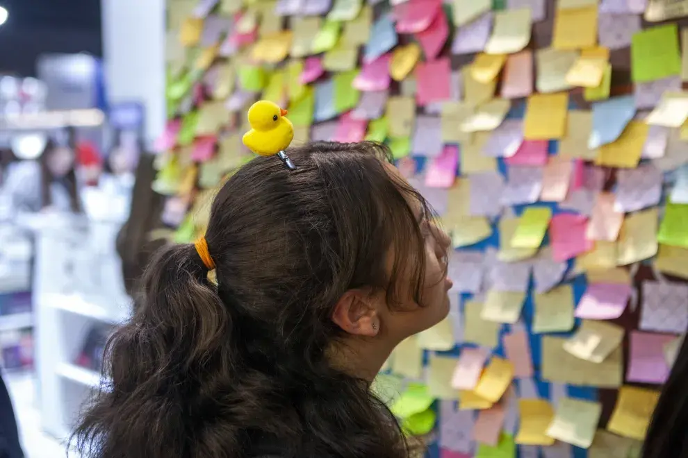 Una chica argentina recorriendo la Feria del Libro con un patito en la cabeza.