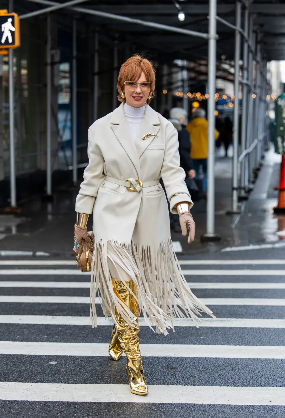 Look de tapado con flecos y botas metalizadas.