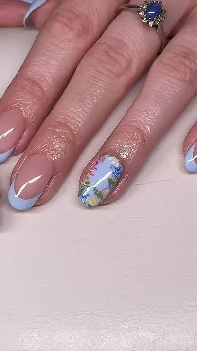 Las uñas con francesita en un celeste pastel y algunas aplicaciones de flores remiten al espíritu Bridgerton.