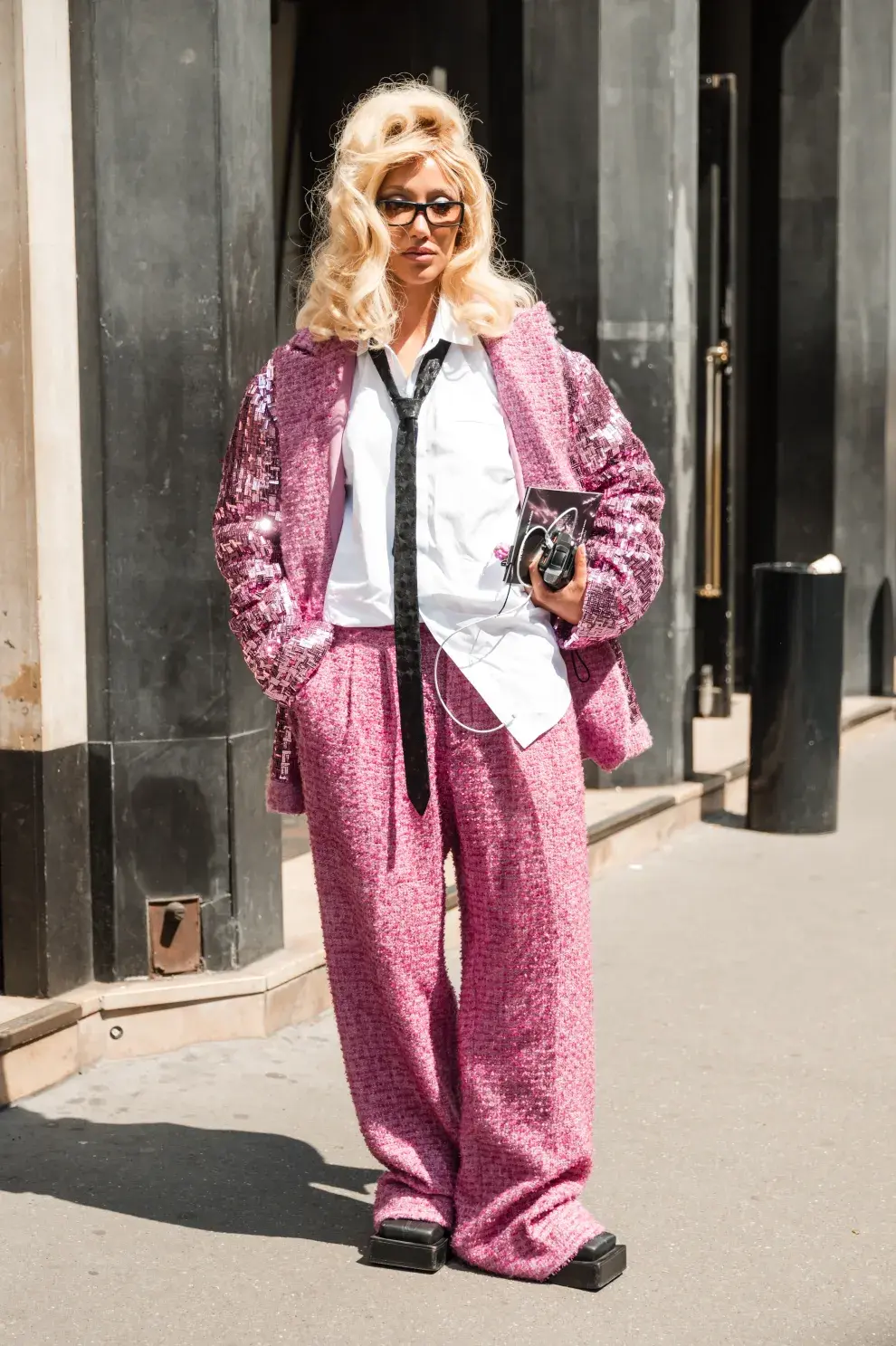 Traje de tweed rosa con mangas con brillo, camisa oversize y corbata. 