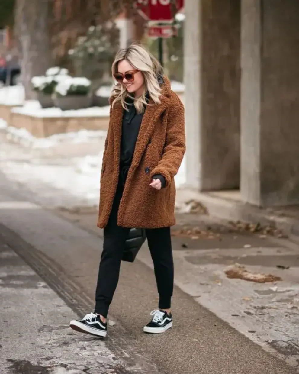 Mujer caminando por la calle con campera teddy bear.