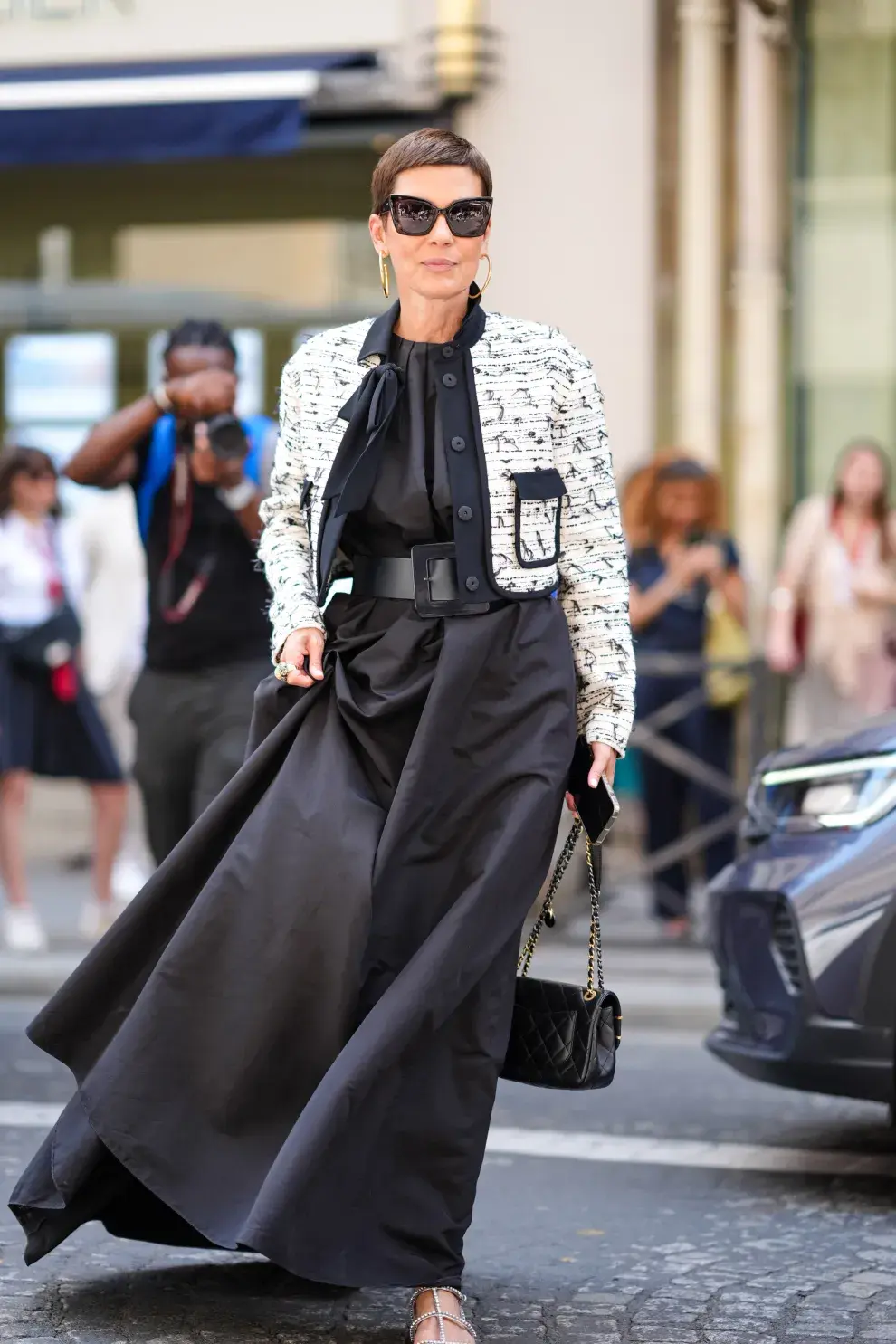 Maxi vestido negro con chaqueta de tweed y cinturón algo. Todo B&W.