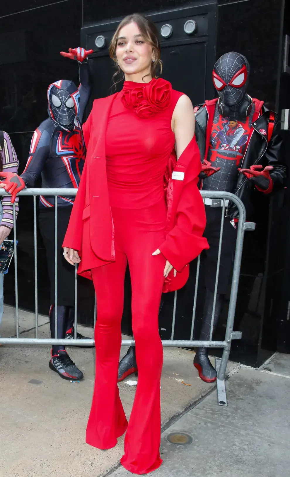 Hailee Steinfeld, con un conjunto rojo rubí: top, flared leggings y blazer sastrero. 