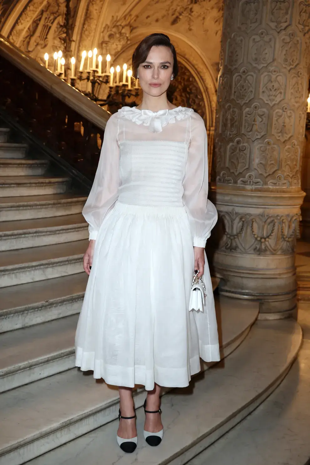 En total white y siempre impecable, Keira Knightley con un vestido midi con transparencias y accesorios al tono.