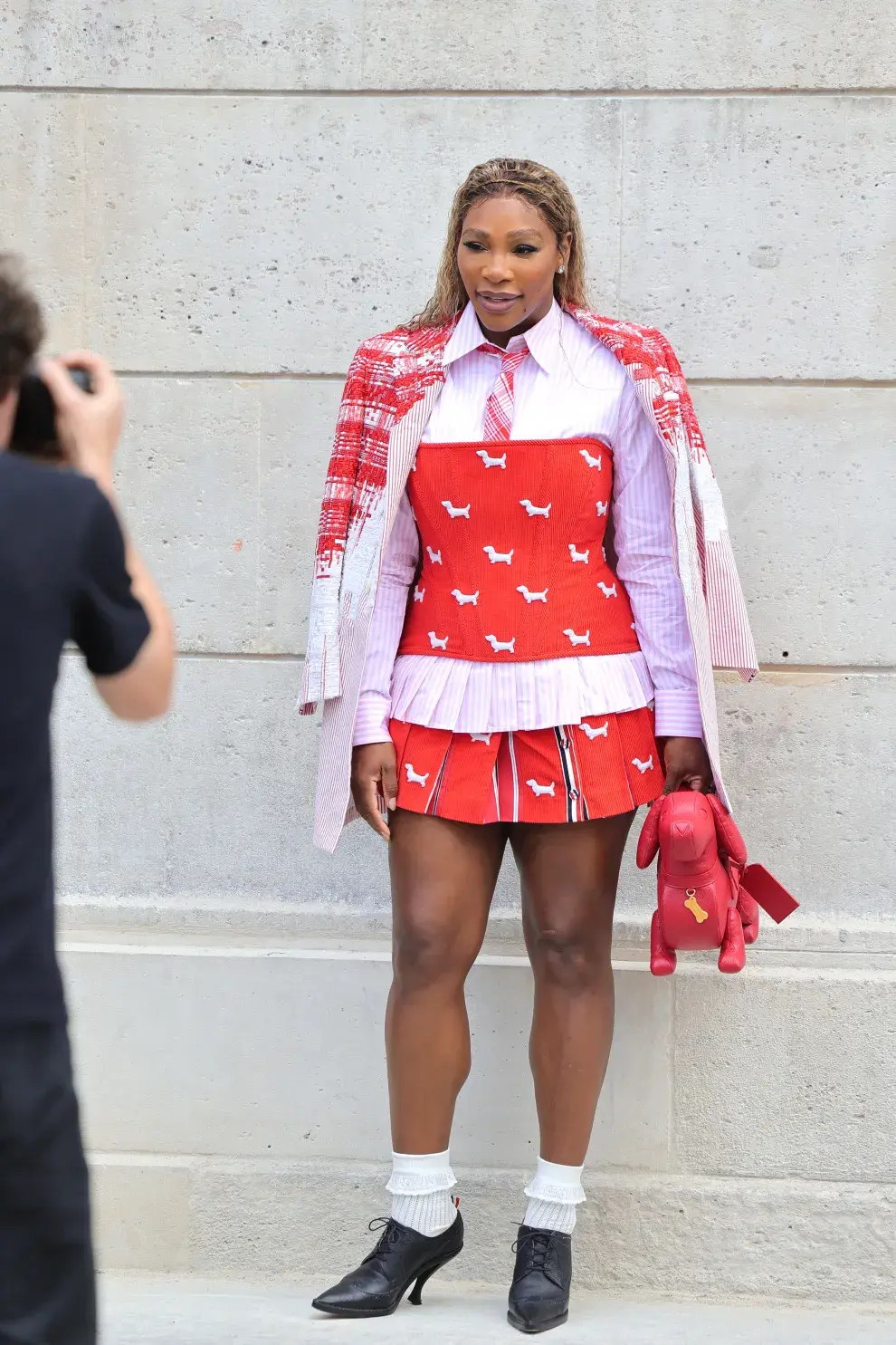 Serena Williams dijo presente en el desfile de Thom Browne abrazando el "tenniscore", una de las tendencias de la temporada, además de usar el rojo, uno de los tonos tendencia. Amamos su look con corbata bien officecore y el detalle de su cartera lúdica, con forma de perro salchicha.