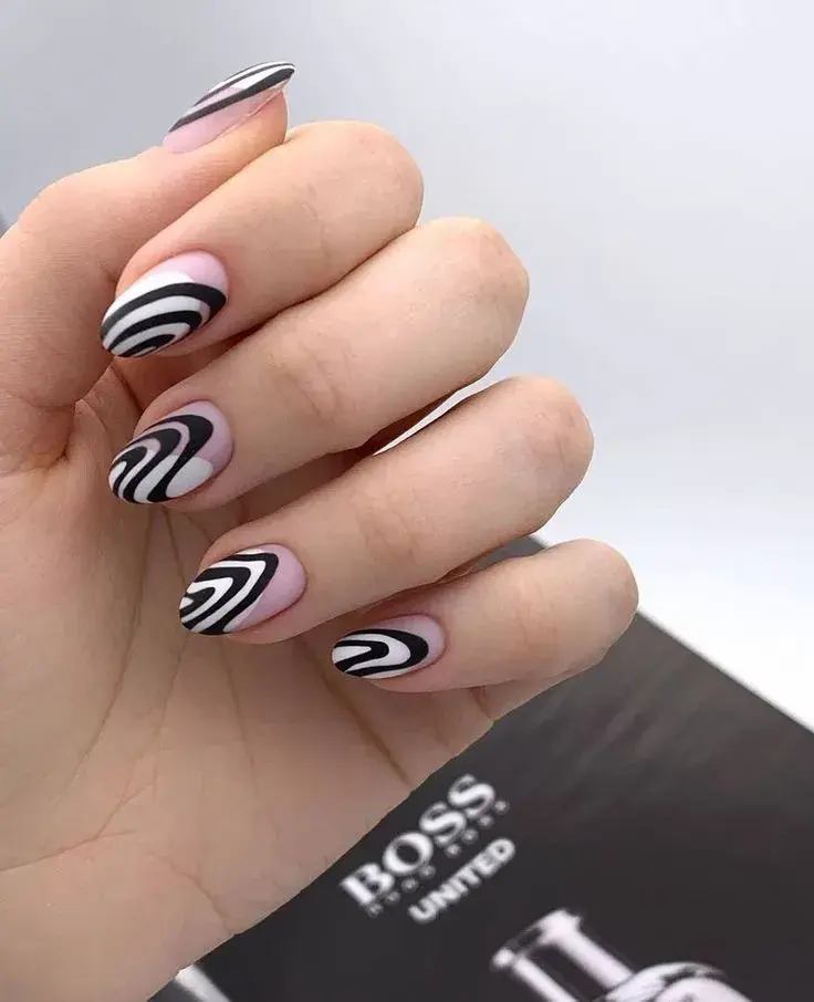 Uñas blanco y negro con líneas abstractas, diseño que está en tendencia.