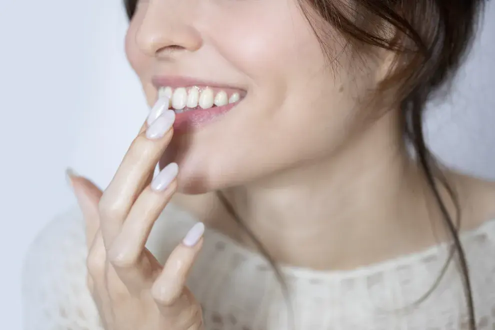 Mujer tocándose los labios con las manos