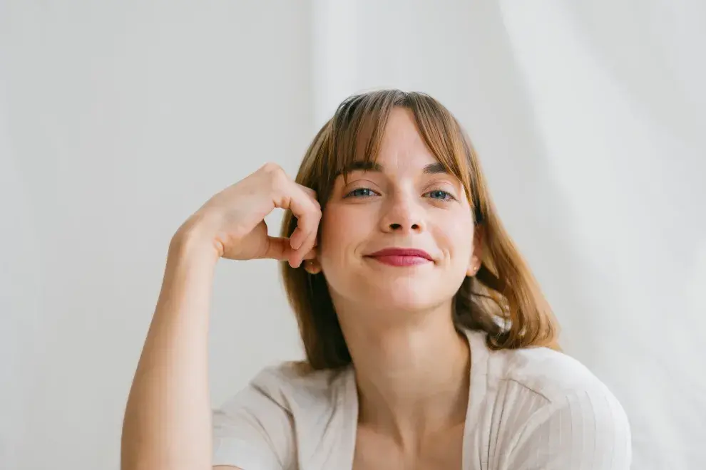 Mujer sonriendo a cámara.