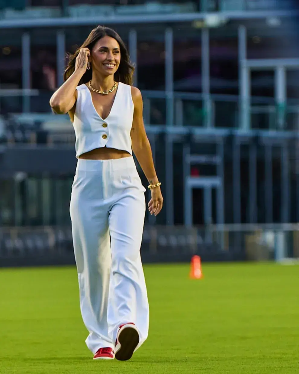 Antonela Roccuzzo caminando en un estadio de fútbol.