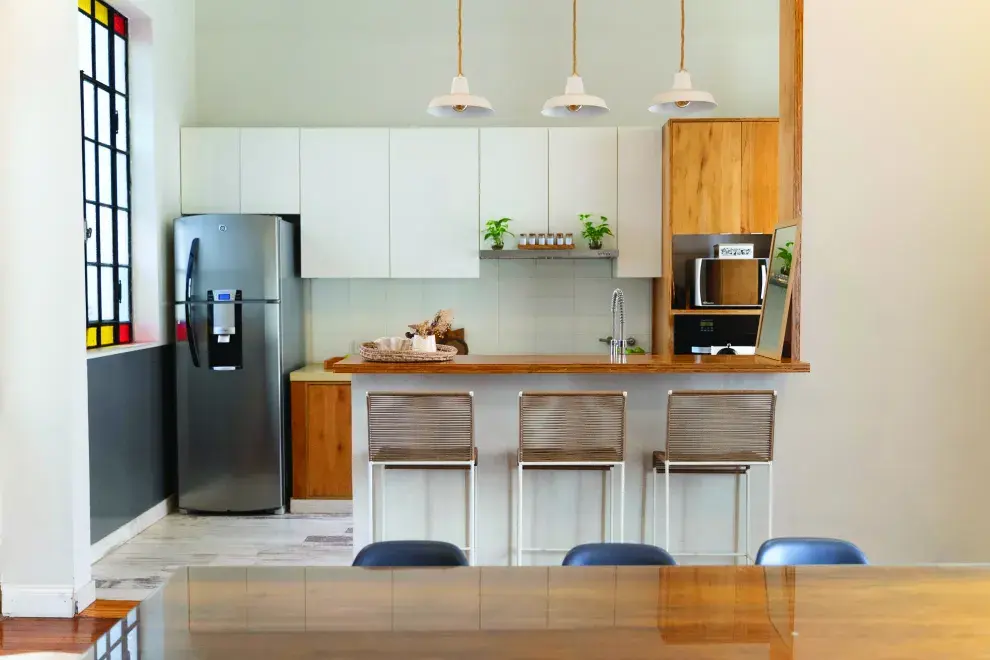 Las cortinas traslúcidas ayudan a que entre la luz natural del balcón al sector de la cocina.