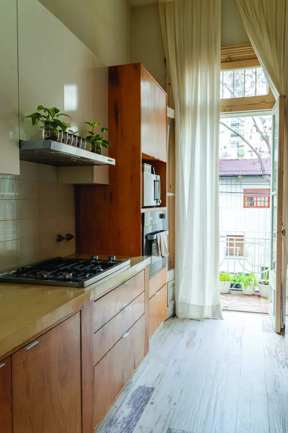 Las cortinas traslúcidas ayudan a que entre la luz natural del balcón al sector de la cocina.