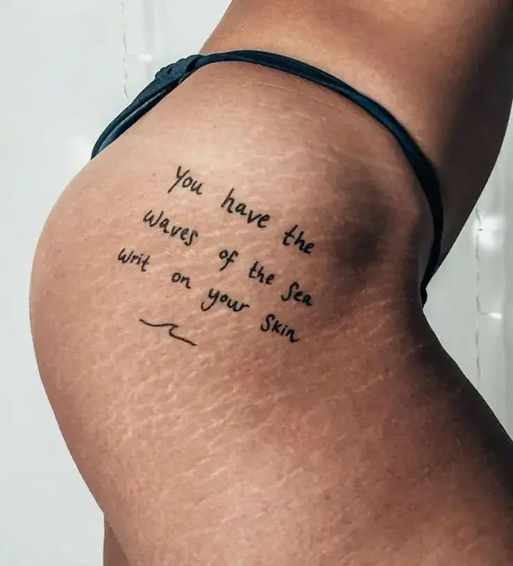 "Tenés las olas del mar escritas en la piel" tatuado sobre estrías.