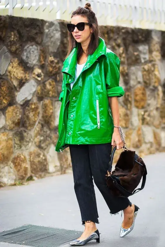 Foto de una mujer en la calle usando un piloto verde.