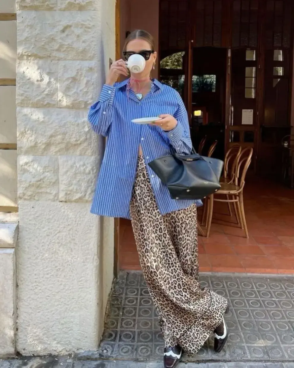 Mujer en la calle tomando un café.