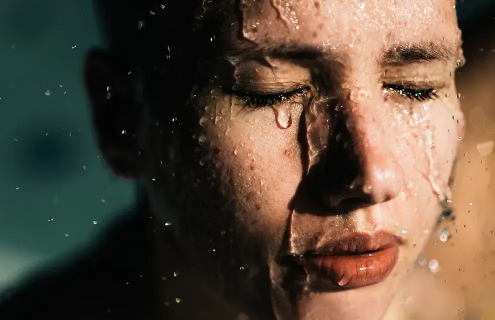 Mujer con el rostro salpicado de agua.