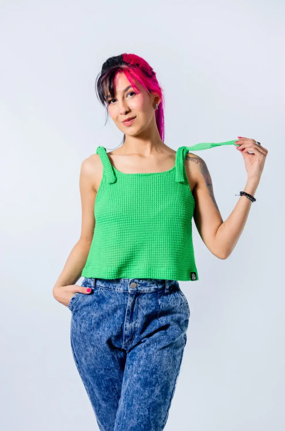 Modelo mujer usando una remera verde.