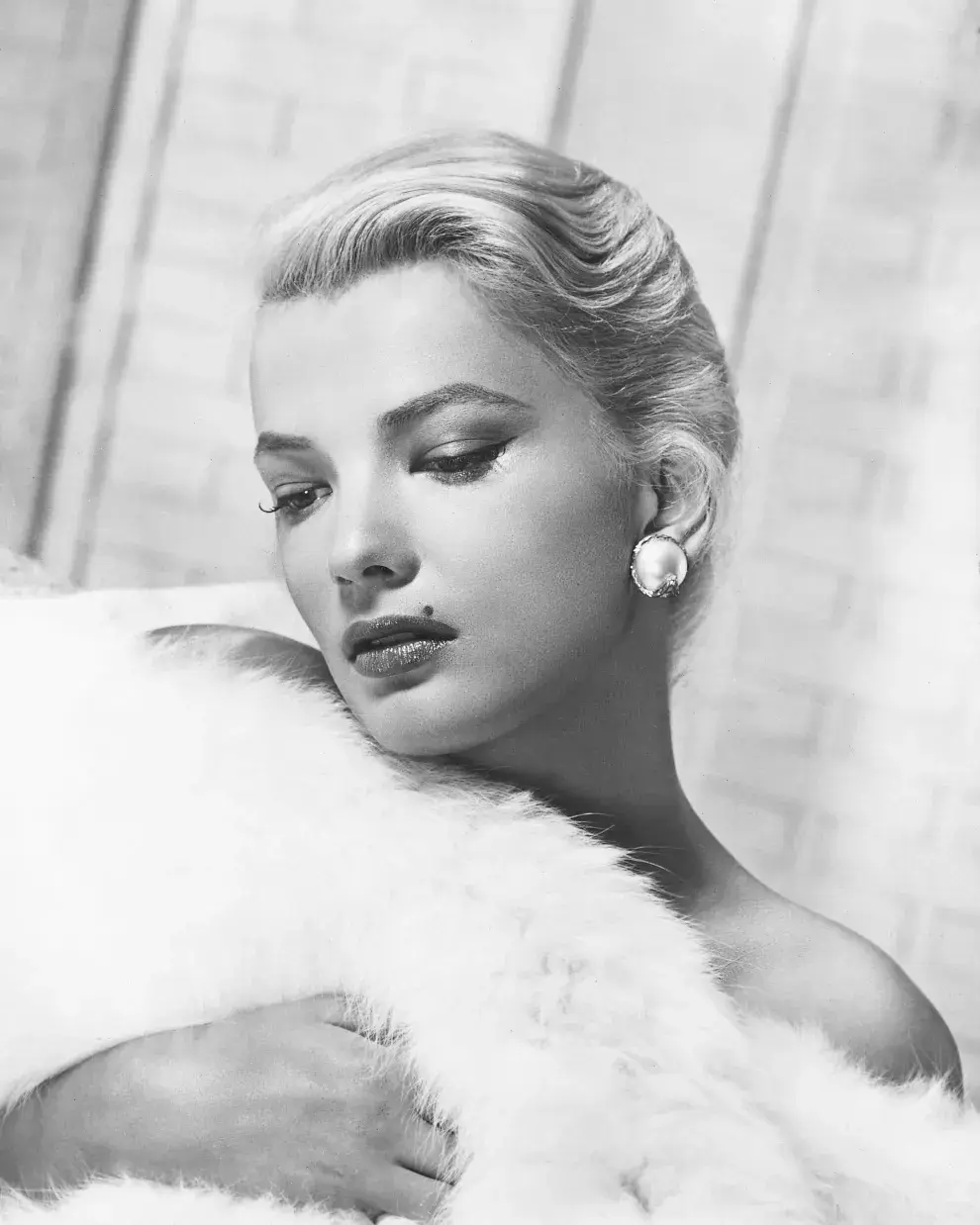 Gena Rowlands, actriz estadounidense, envuelta en piel blanca en un retrato de estudio, alrededor de 1955.