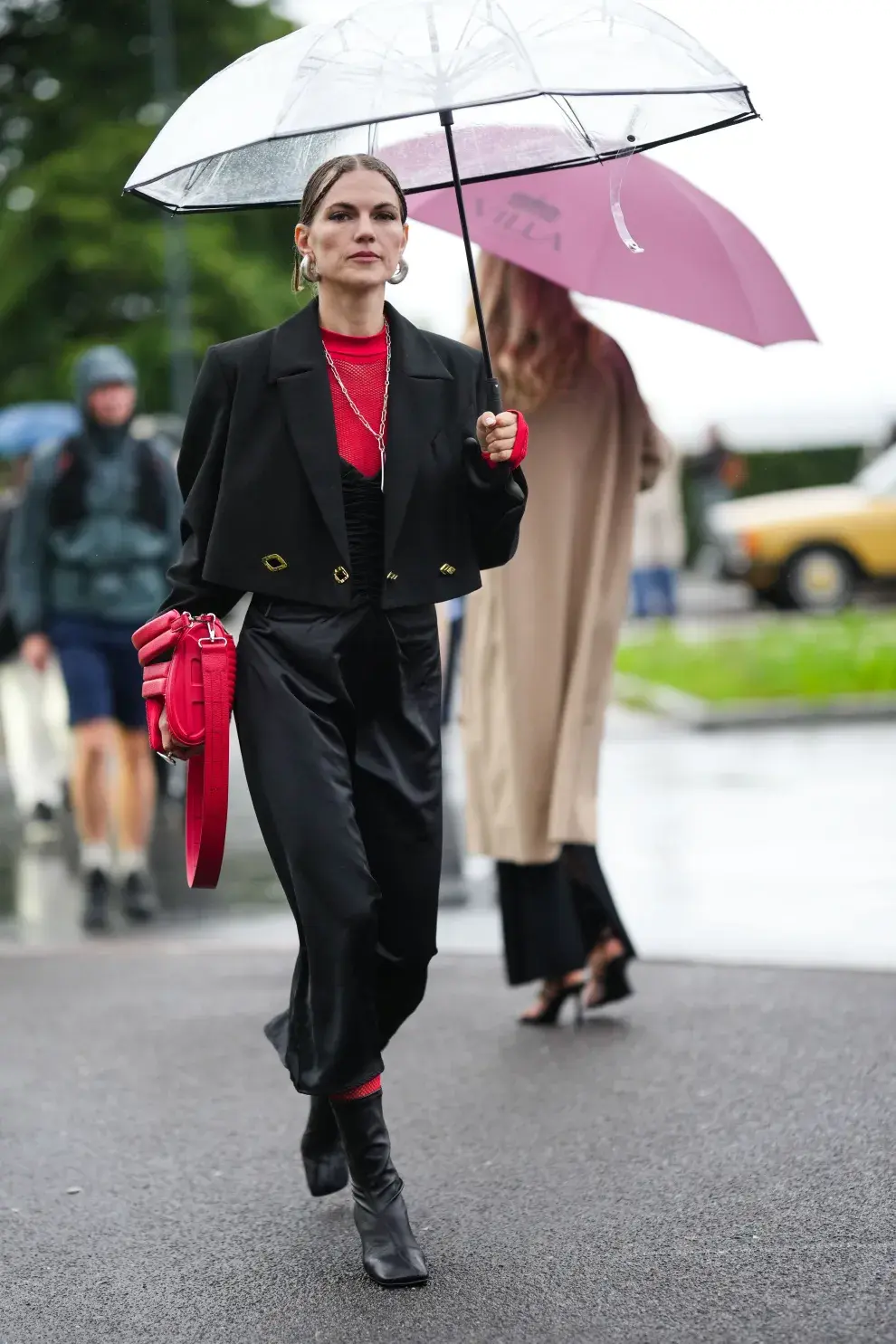 Mujer muy bien vestida bajo la lluvia con un paraguas