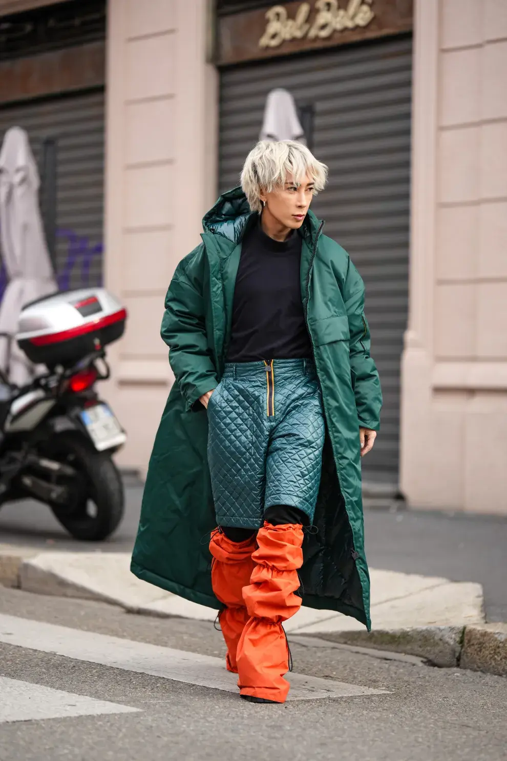 Mujer con piloto verde y cubre botas naranjas.